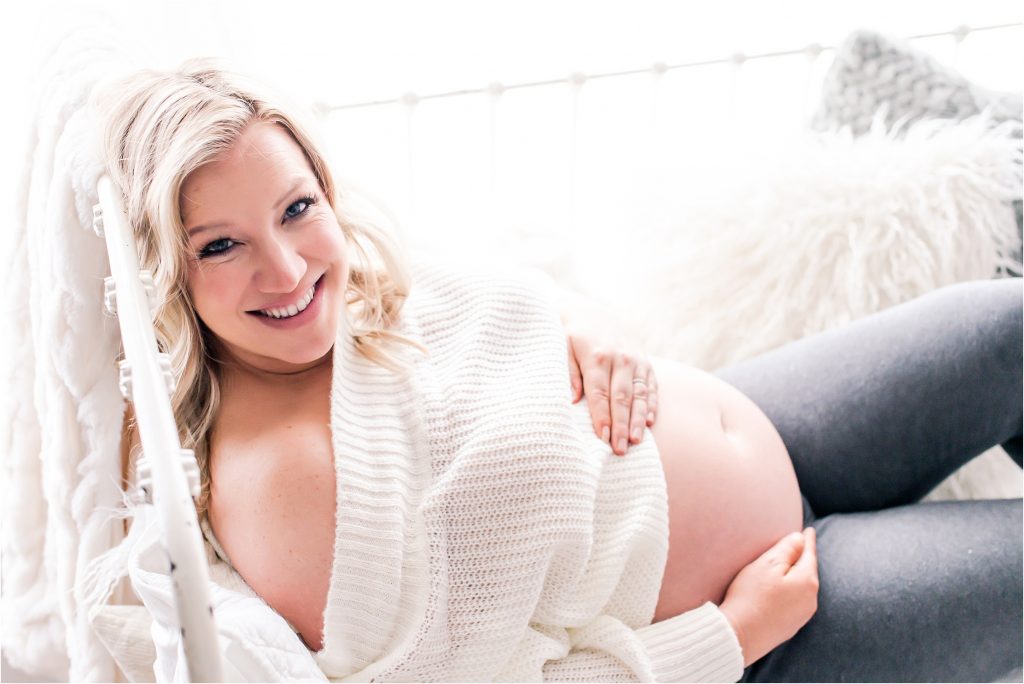 mom showing off baby belly in studio maternity session