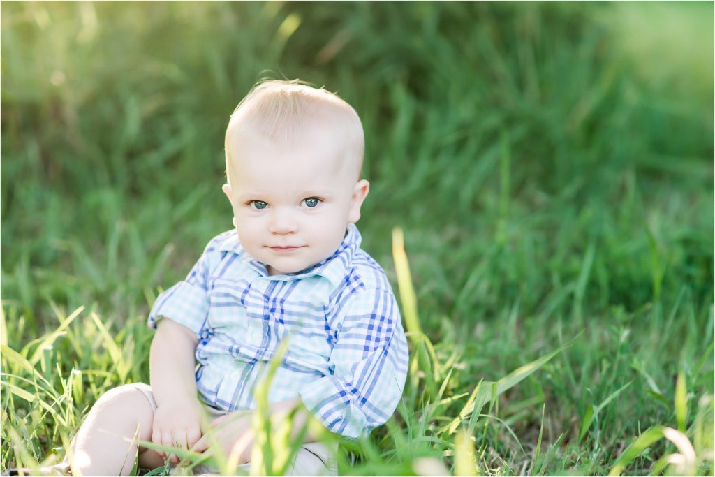 One year old boy sitting in the grass