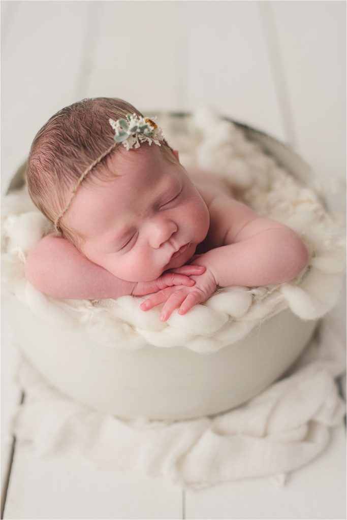 baby girl on white wood in white bucket