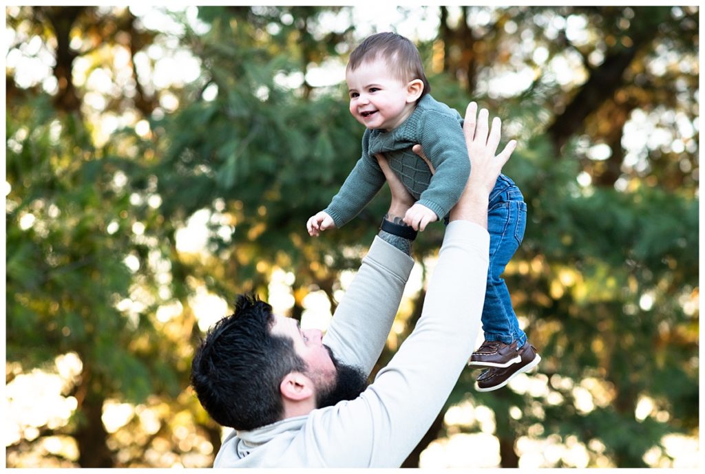 Dad tossing one year old baby boy in air