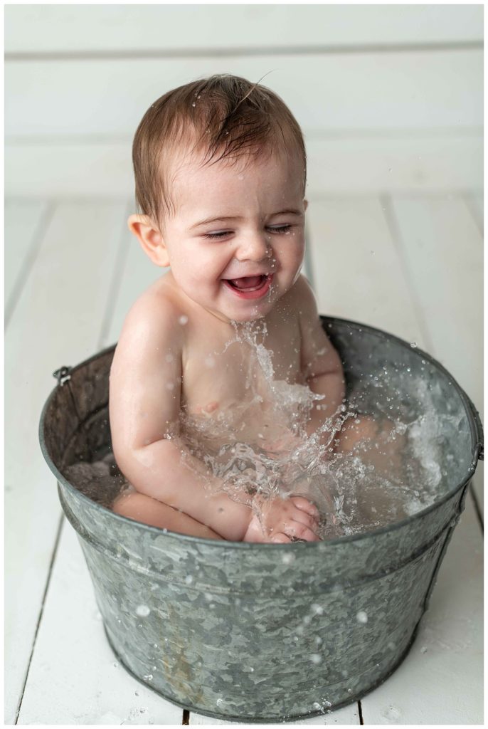 baby boy looking at water and laughing in basin