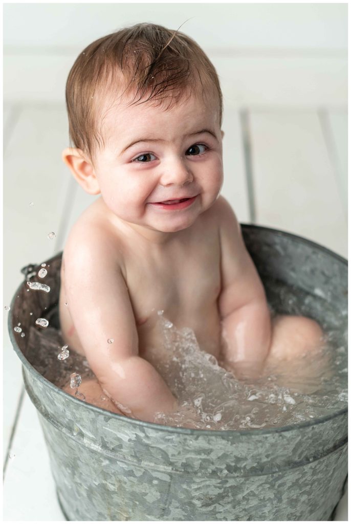 baby boy splashing and laughing in basin