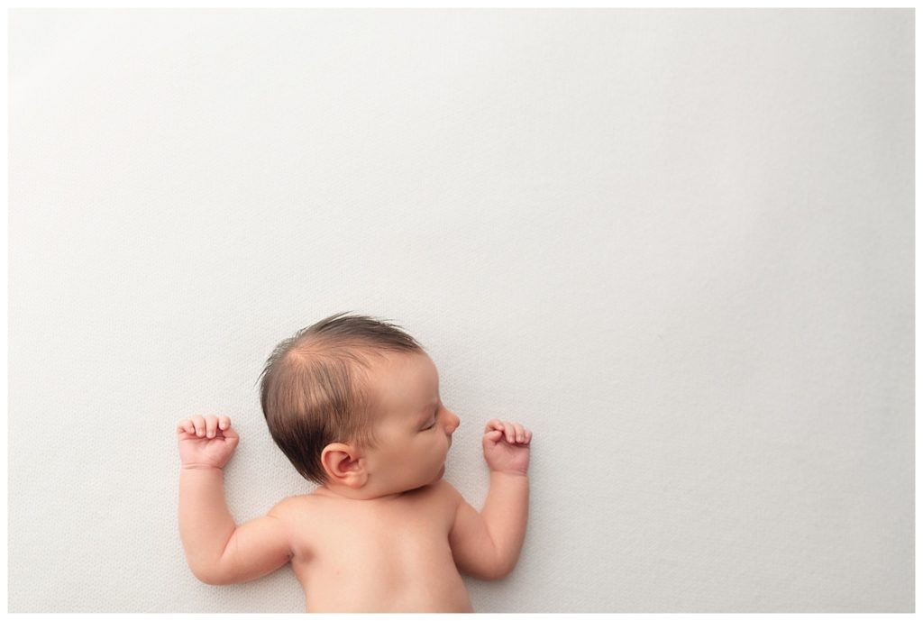 candid shot of baby boy on white backdrop